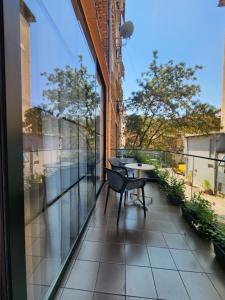 a balcony with a chair and a table on it at Vatër Apartments in Tirana
