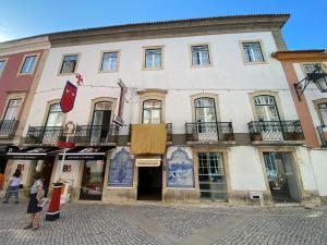 una mujer parada frente a un edificio en União - Guest House, en Tomar