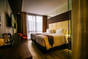 um quarto de hotel com uma cama e uma janela em Asialink Hotel Batam by Prasanthi em Nagoya