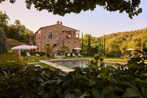 a large stone house with a pool in front of it at Podere la Casina Country Chic in Rigomagno