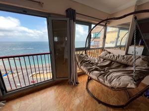 a room with a hammock and a view of the ocean at Panoramic Sea View Flat miami FAMILY ONLY شقة بانورما بشاطئ ميامي الاسكندرية عائلات فقط in Alexandria