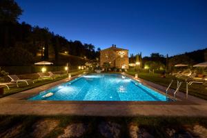 una piscina frente a una casa por la noche en Podere la Casina Country Chic, en Rigomagno