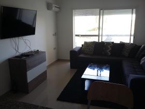 a living room with a couch and a tv at Appartment avec Belle Vue sur Golf in Asilah