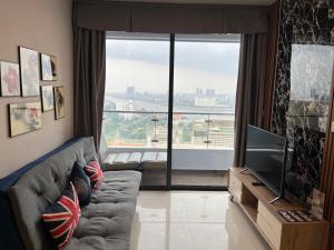 uma sala de estar com um sofá e uma grande janela em The Bridge Club em Phnom Penh