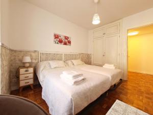 a bedroom with two beds and a table with a lamp at APARTAMENTO Delia in Gijón