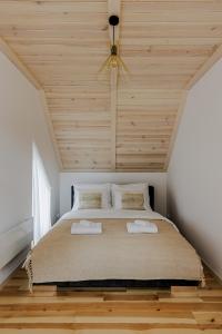 a bedroom with a large bed with a wooden ceiling at Rzecznicy Relaksu in Długosiodło