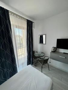 una camera con letto, tavolo e finestra di Luxury by SARAY a Eforie Nord
