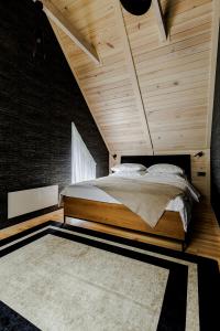 een slaapkamer met een bed en een houten plafond bij Rzecznicy Relaksu in Długosiodło