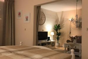 1 dormitorio con 1 cama y mesa con TV en Ferienwohnung An der Therme, en Bad Aibling