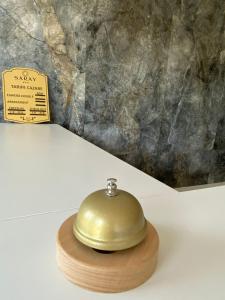 um sino de ouro sentado numa mesa ao lado de um sinal em Luxury by SARAY em Eforie Nord