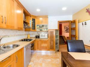 a kitchen with wooden cabinets and a sink at Casa samia in Cónchar