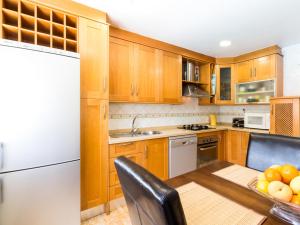 cocina con armarios de madera y nevera blanca en Casa samia, en Cónchar