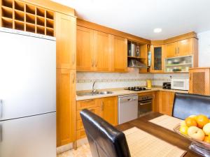 uma cozinha com armários de madeira e um frigorífico branco em Casa samia em Cónchar