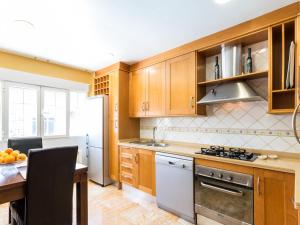uma cozinha com armários de madeira e um forno com placa de fogão em Casa samia em Cónchar