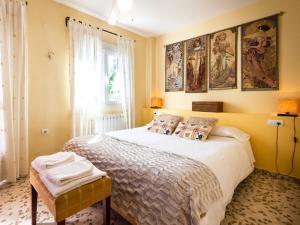 1 dormitorio con 1 cama grande con pinturas en la pared en Casa samia, en Cónchar