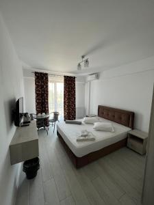 una camera con un grande letto e un tavolo di Luxury by SARAY a Eforie Nord