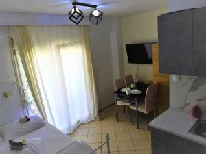 um quarto com uma cama, uma mesa e uma cozinha em Konstantinos's Luxury Studio em Tessalônica