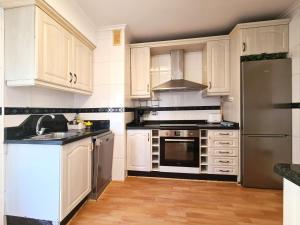 a kitchen with white cabinets and stainless steel appliances at APARTAMENTO Delia in Gijón