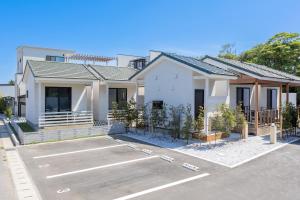 una casa con un estacionamiento delante de ella en Innocence Resort -in Chiba Resol-, en Hasunuma