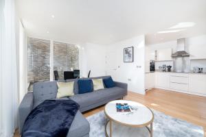 a living room with a blue couch and a table at Chic London 1 bedroom flat in London