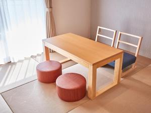 a wooden table with two chairs and a table with two stools at Ocean View in Kibogaoka in Onna