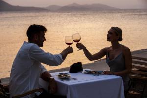 Ein Mann und eine Frau, die an einem Tisch mit Gläsern Wein sitzen in der Unterkunft TUI BLUE Kalamota Island - All Inclusive in Dubrovnik