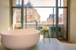a bath tub in a room with a large window at W Amsterdam in Amsterdam