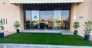 a green lawn in front of a building at Al Massa Plus Hotel in Al Ain