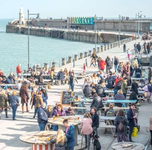 a group of people sitting at tables on a pier at Palmbeach Place in Kent