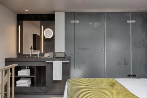 a bathroom with a shower and a sink and a bed at W Amsterdam in Amsterdam