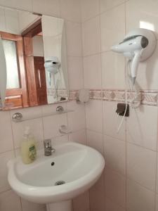 y baño con lavabo blanco y espejo. en Akya Adrasan Pansiyon, en Adrasan