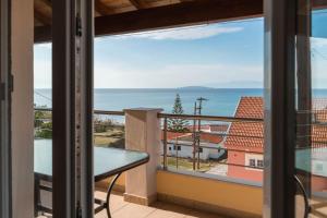 een balkon met uitzicht op de oceaan bij Antheia Apartments in Agios Stefanos