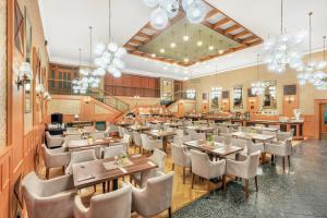 杰尔Danubius Hotel Raba的有桌椅和吊灯的餐厅