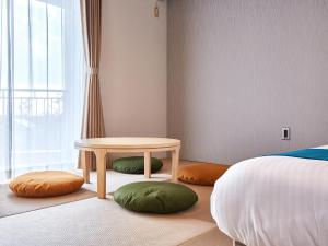 a bedroom with a table and pillows and a bed at Ocean View in Kibogaoka in Onna