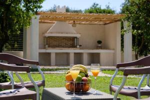 a table with a bowl of fruit and a glass of orange juice at Villa Xampelo in Nýmfai