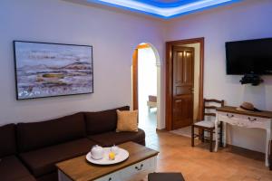 ein Wohnzimmer mit einem Sofa und einem Tisch in der Unterkunft Antheia Apartments in Agios Stefanos