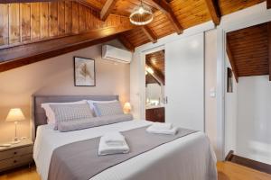 a bedroom with a large bed with two towels on it at Peroulades Luxury Villa in Peroulades