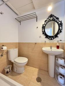 a bathroom with a toilet and a sink and a mirror at Duplex Exterior Madrid Centro Esperanza in Madrid