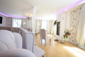 a white room with white chairs and a table at Hotel Haus Rödgen in Wilnsdorf