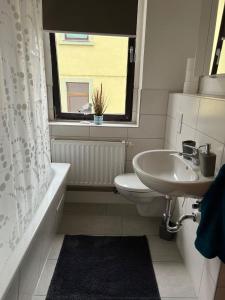 a bathroom with a sink and a toilet and a window at Wolke 7 in Freital