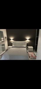 1 dormitorio con cama blanca y pared negra en Pindemonte house, en Quartu SantʼElena