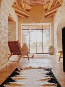 ein Wohnzimmer mit einem Stuhl und einem großen Fenster in der Unterkunft Maison Belhazar in Essaouira