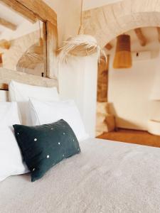 a black pillow sitting on a bed with white pillows at Maison Belhazar in Essaouira +32 photos