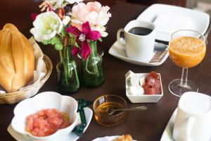 einen Tisch mit Teller mit Speisen und einer Tasse Kaffee und Blumen in der Unterkunft La Asomada del Gato in La Laguna