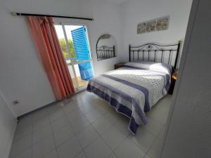 een slaapkamer met een bed en een groot raam bij La Almadraba in Novo Sancti Petri