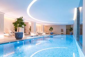 a swimming pool in a hotel with a circular ceiling at Hotel The Peninsula Paris in Paris