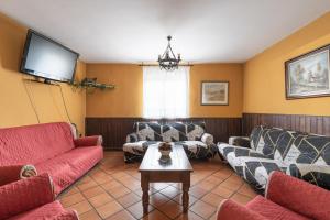 Il comprend un salon avec des canapés et une télévision à écran plat. dans l'établissement Casa Rural Las Melias, à Ciudad Real