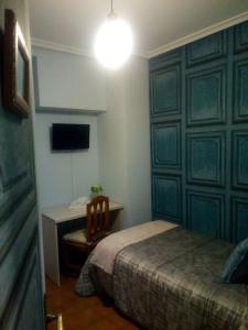 1 dormitorio con 1 cama y escritorio con TV en Pension ILARRAZABAL, en Azpeitia