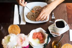 a table topped with plates of food and a person eating at La Asomada del Gato in La Laguna