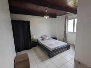 - une chambre avec un lit et un rideau noir dans l'établissement T2 APPIETTO, à Appietto